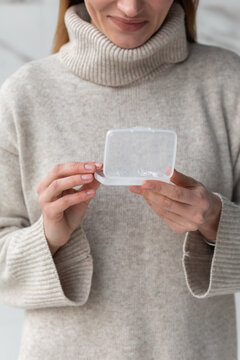 Blonde woman holding Retainer Box