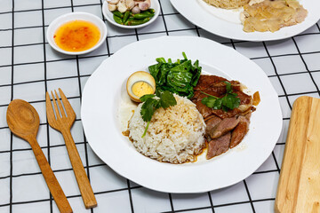 Stewed pork leg with boiled egg and rice on a plate.