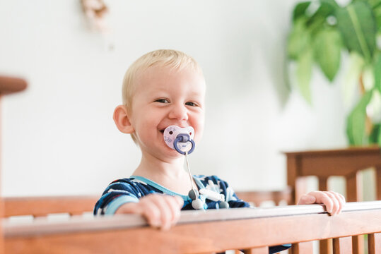 Portrait of Grinning Toddler Boy Smiling Out of Crib
