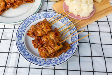 Grilled skewered milk pork with white sticky rice - local Thai street food style