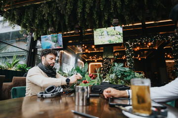 A young man engages in business on his smart watch at a vibrant coffee shop decorated with fairy lights and greenery.