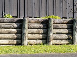 Cantilever wooden half rounds pole retaining wall. For residential sites.