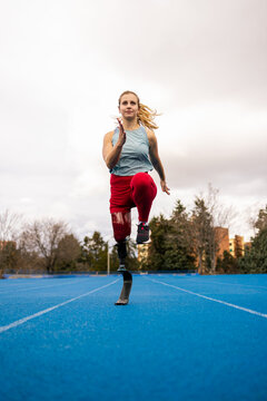 Young paralympic athlete with a bionic leg prosthesis sprinting