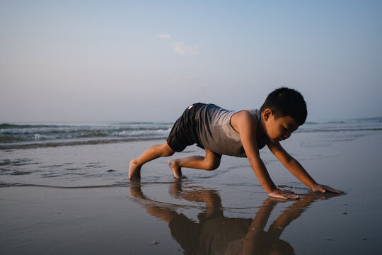 Asian boy playing on the beach