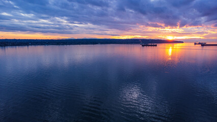 Container ships sitting in the calm Burrard Inlet at sunset