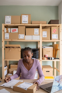 Focused logistic manager ticking items on list