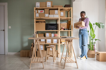 Busy female manager checking carton boxes near shelves