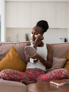 Sensual black female tweezing eyebrows at home