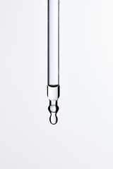 Clear liquid droplets falling from a dropper that can be used for cosmetic and medical images.