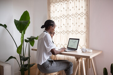 Black female architect working on laptop