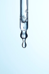 Clear liquid droplets falling from a dropper that can be used for cosmetic and medical images.