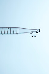 Clear liquid droplets falling from a dropper that can be used for cosmetic and medical images.