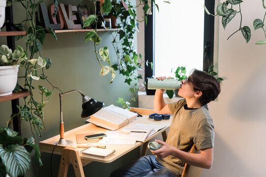 Teen Boy Drinking Water On The Desk At Study Room
