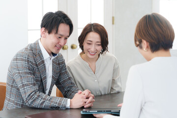 ブライダルプランナーと結婚式の打ち合わせをするカップル