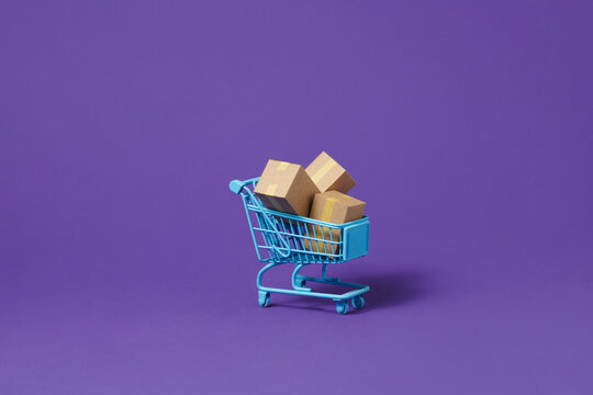 Cartons or Paper boxes in red shopping cart on purple