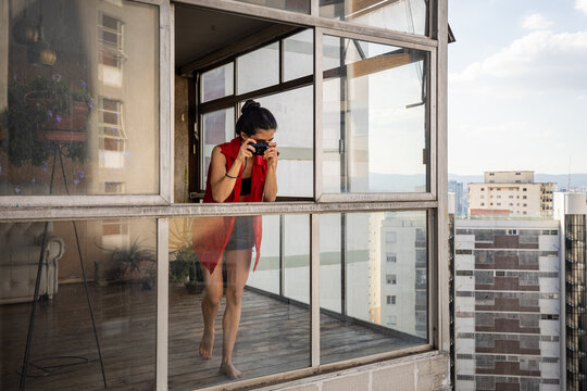 Stalker woman taking pictures of neighbours from her building