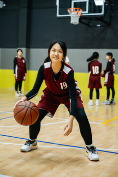 Teenage girl wearing basketball uniforms and doing drills at practice
