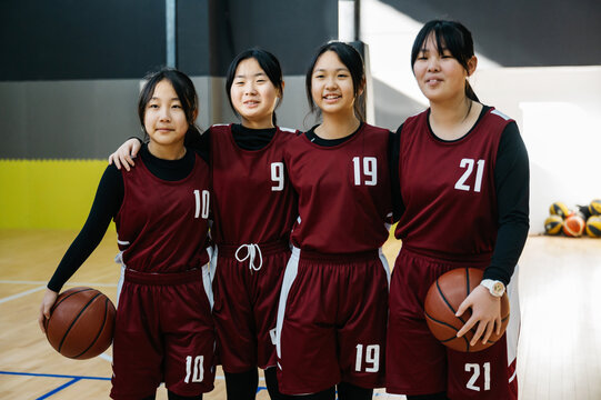 Portrait of two basketball girls team in a gym