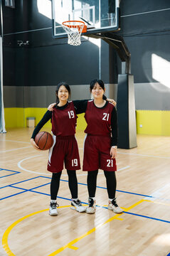 Portrait of two basketball girls team in a gym