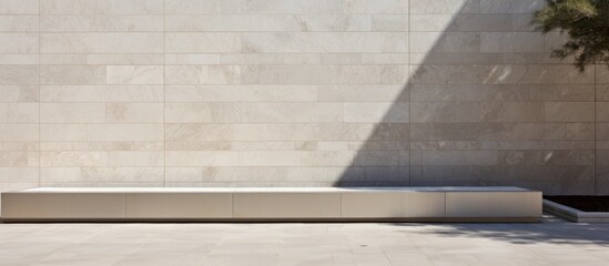 A concrete bench is positioned in front of a sleek grey limestone wall. The contrast between the rough concrete and smooth limestone creates a modern and industrial aesthetic.