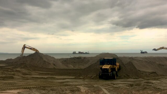 March 1, 2022 - Jomtien Beach, Chonburi Thailand. Large excavation machines build up the coastline with sand brought in from ships docked in the Gulf of Thailand.