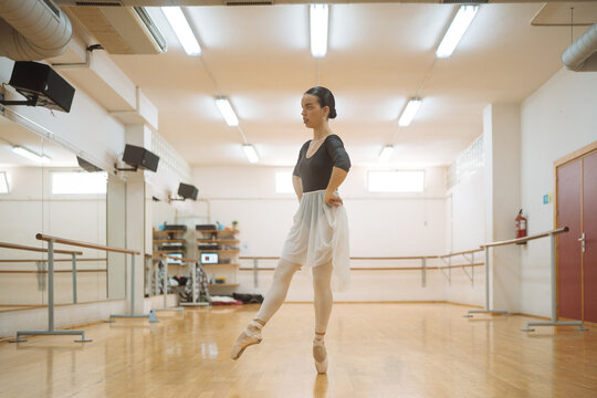 Young dancer practicing ballet dance in illuminated class