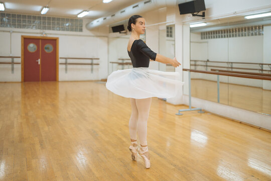 Gracious ballerina dancing on tiptoes during rehearsal