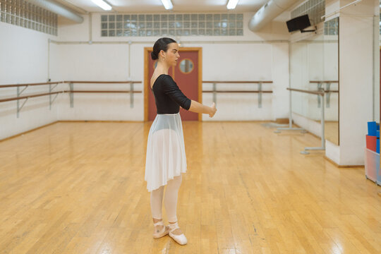 Serious ballerina standing in studio during rehearsal