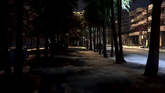 April 5, 2022 - Jomtien Beach, Chonburi, Thailand. Walking along a dark and dimly lit promenade in the early hours of the morning before the sunrise.