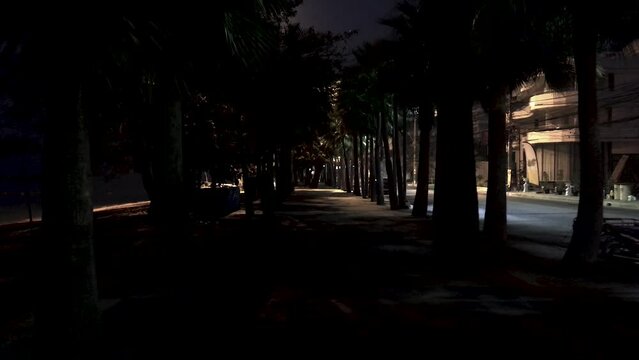 April 5, 2022 - Jomtien Beach, Chonburi, Thailand. Walking along a dark and dimly lit promenade in the early hours of the morning before the sunrise.