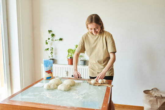 Young woman cutting mushrooms for pizza