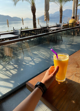 Crop person with glass of fresh orange juice