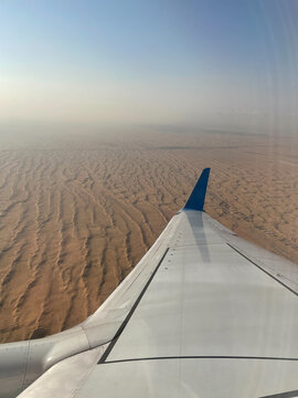 Airplane wing over desert