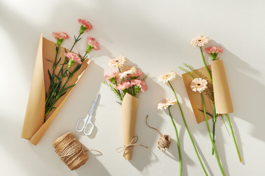 Beautiful spring flowers in wrapping paper, scissors and rope