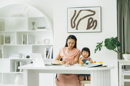 Asian young single mother working on computer