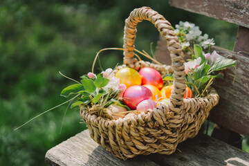 A basket of colorful Easter eggs. Children are looking for Easter eggs in nature in the grass....