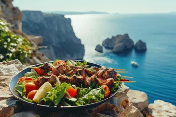 Photo sur Plexiglas Europe méditerranéenne Vegetable salad and souvlaki on skewers in front of the sparkling blue sea during summer
