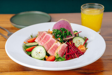 A plate of food with a glass of orange juice on a table