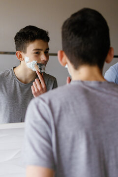 Teenager boy shaving stubble razor