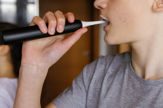 Anonymous boy brushing teeth washroom morning 