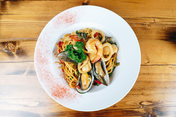 A plate of food with shrimp and noodles on a wooden table