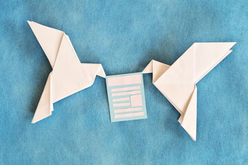 Two paper dove origami carrying email newsletter document in blue background.
