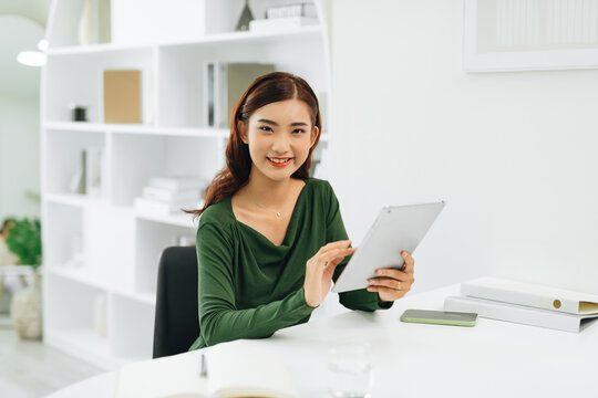 Young Asian woman with tablet, smiling to camera