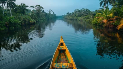 Foto op Canvas A serene tropical river winding through a dense rainforest, a canoe visible in the distance exploring the area © akarawit