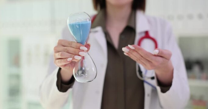 Female doctor holds hourglass in clinic
