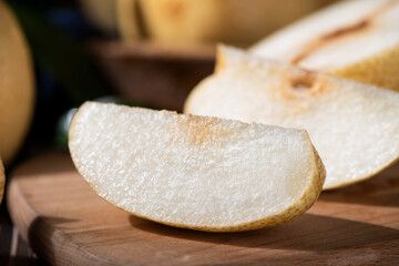 fresh Asian pear fruit and half sliced on wooden table.