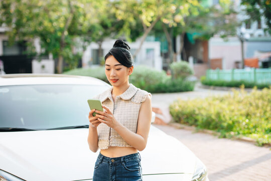 Woman Using Mobile Phone Near Car