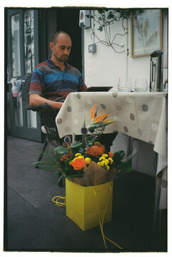 Film man at restaurant with menu and flowers