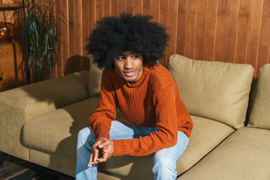 Man with afro hair sitting on couch