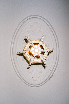 Underside view of lit chandelier against decorative plaster details